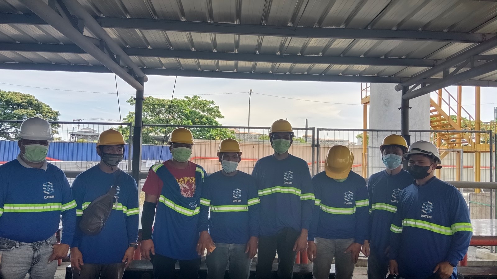 AMYO project team wearing protective work clothing at a construction site
